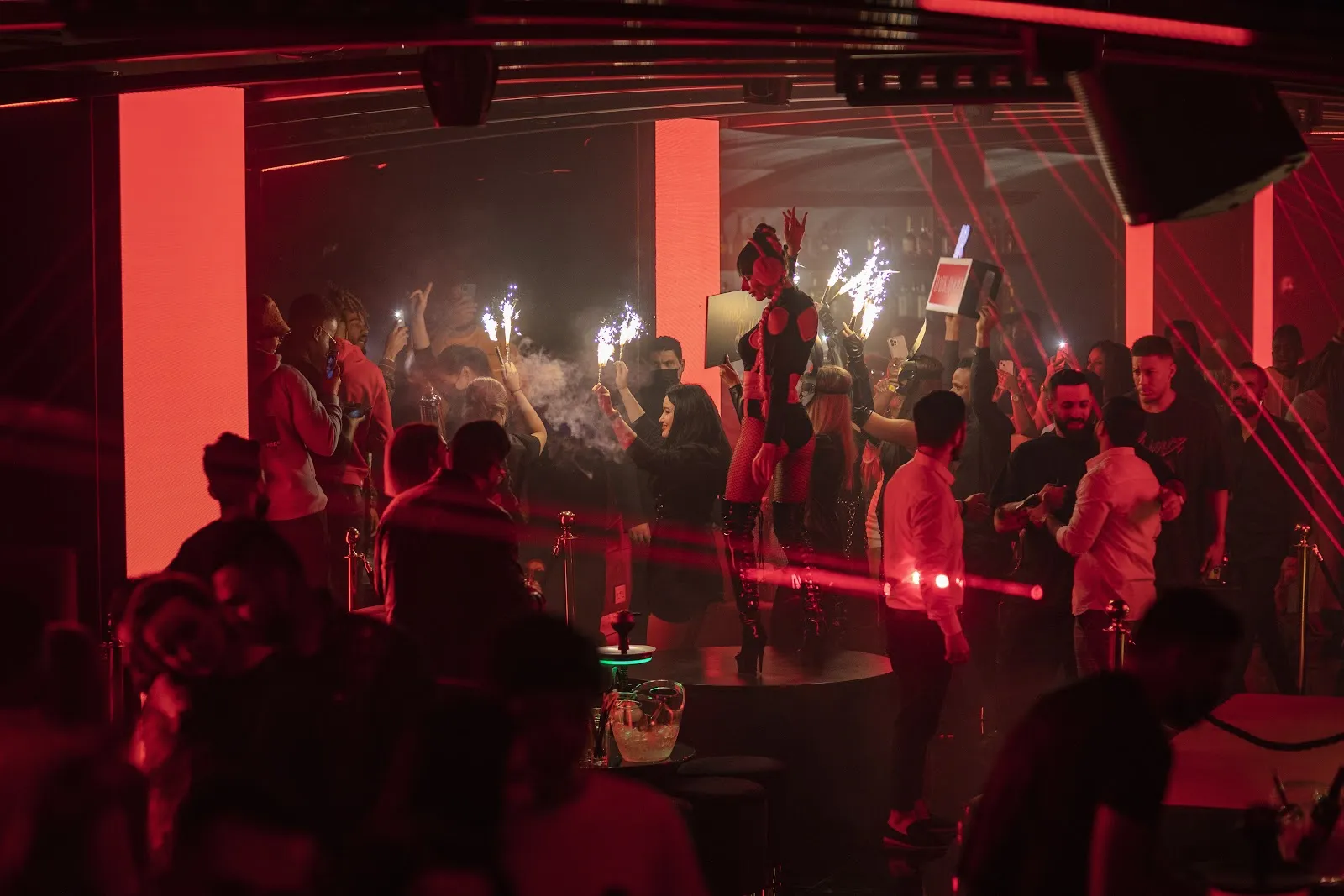 Crowd dancing under red lights on a busy night at Dark Room Dubai Night Club