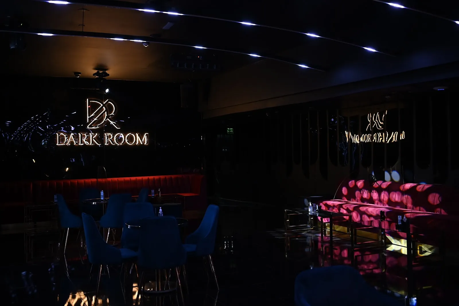 Main room with blue seating and pink lounge sofas at Dark Room Dubai in Trade Centre 1